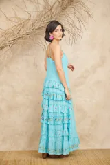 Vestido largo blanco con breteles finos ajustables, corte imperio, volados en vainilla y bordados florales.