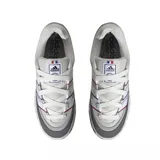 Championes Adidas Adimatic color gris claro con detalles en gris oscuro y blanco. Presentan las tres tiras características de Adidas en blanco con bordes en azul y rojo.