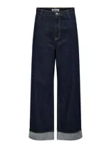 Pantalón de jean azul oscuro, de pierna ancha y tiro alto, con bragueta de botones, dobladillo doblado y pasadores para cinturón.