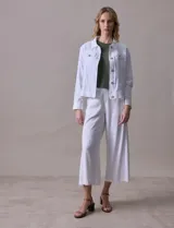 Campera de lino color beige, marca Dash, con abertura central y botones. Tiene bolsillos aplicados en la parte delantera.