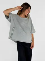 Remera color amarillo con cuello redondo y mangas cortas amplias, con detalle de botones en los laterales.