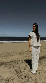 Pantalón blanco de broderie con tiro medio, cintura elástica, short de forro y pespunte negro en la terminación.