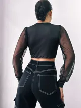 Top negro de microfibra con manga larga de red, diseño ajustado y lazo frontal.