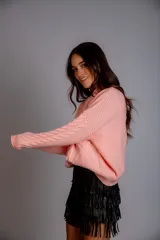 Sweater color crudo con cuello alto y diseño trenzado.