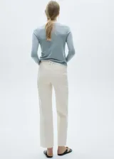 Pantalón de jean culotte color crema, tiro alto, con cierre de cremallera y botón, trabillas, bolsillos traseros, bajo deshilachado y tejido elástico.