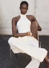 Top blanco de punto fino con cuello halter y diseño entallado.