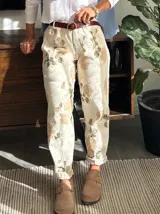 Pantalón de pana color crudo con estampado floral en tonos beige y marrón.