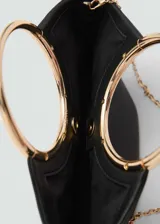 Bolso negro con efecto piel, forro interior, asa de mano, doble asa corta, asa larga extraíble, detalle metálico y cierre de imán interior.