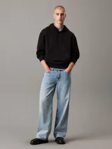 Buzo negro con capucha y cordón ajustable, de corte regular, con puños y bajo de canalé, bolsillo canguro y logo bordado tonal en el pecho y estampado en la parte trasera.