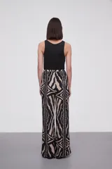 Pantalón de viscosa con estampado abstracto en tonos beige y negro, de corte palazzo y cintura con lazo ajustable.