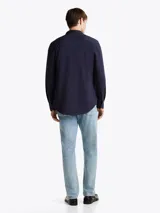 Camisa Tommy Hilfiger de manga larga azul marino, corte slim y cuello abotonado. Confeccionada en mezcla de algodón y poliéster.