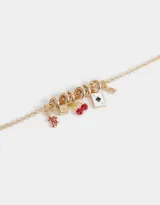 Collar corto dorado con cadena de eslabones y dijes colgantes: dados, cerezas, naipe y serpiente.