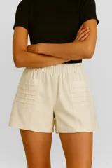 Short color beige de lino y viscosa, con bolsillos laterales, cintura alta con elástico y corte holgado.