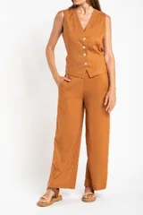 Pantalón de lino color ocre, de corte recto y tiro medio, con lazo de ajuste en la cintura.