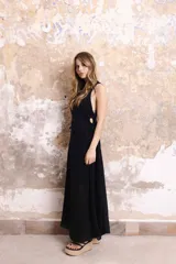 Vestido largo negro sin mangas, con corte en la cintura y aberturas con frunce en los costados. Confeccionado en tela tejida de lino.
