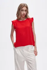 Blusa roja de poliéster con cuello a la base y volados en los hombros.
