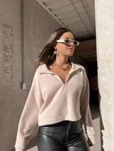 Buzo color rosa claro de tela Aspen con cuello polo y cierre parcial.