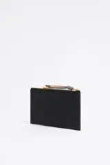 Cartera negra de nylon con estructura blanda. Cuenta con asa de tejido, logo metálico BIMBA Y LOLA, acabados metálicos, tarjetero interior, cierre con cremallera e interior con placa logotipada metálica BIMBA Y LOLA.