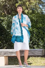 Echarpe blanca de gasa de seda natural con lana Merino superfina en tonos azules y turquesas, con volados en los extremos.