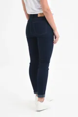 Jean chupín azul oscuro de tiro medio, con cierre de botón y cremallera, bolsillos delanteros y traseros, y dobladillo enrollado.