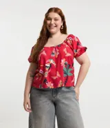 Blusa plus size con mangas cortas abullonadas y elástico en los hombros. Prenda confeccionada en viscolino y estampada con motivos de follajes y tucanes.