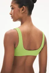 Top de bikini verde con textura, breteles anchos y anilla revestida en el centro del busto.