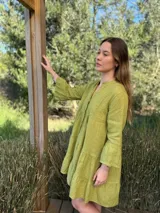 Vestido corto negro de lino, con escote en V, botones frontales y mangas largas acampanadas con volados.