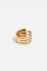 Anillo ancho y ajustable de metal dorado, compuesto por varias bandas horizontales. En uno de los extremos, las bandas terminan en forma de corazón redondeado.