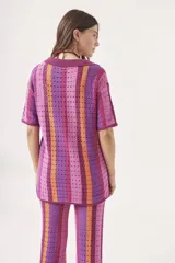 Sweater de tejido crochet a rayas verticales en tonos azul, verde, marrón y blanco, con cuello polo y cierre de botones.