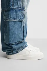 Zapatillas deportivas blancas de estilo skate con cordones gruesos y suela con plataforma.