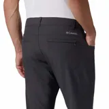 Pantalón de vestir negro, de corte recto, con bolsillos laterales y traseros. Se ajusta a la cintura con cinturón de cuero marrón.