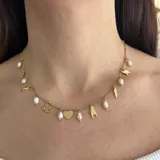 Collar dorado de acero con cadena de eslabones y dijes colgantes de amuletos y perlas de río.