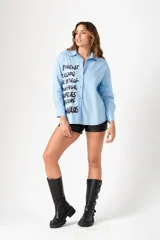 Camisa celeste de corte clásico, con cuello camisero, manga larga y cierre frontal con botones.