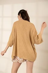 Remerón tejido color ocre, de corte oversize, con mangas 3/4 y cuello redondo.