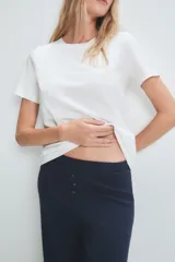 Pantalón acampanado azul marino de tejido de punto acanalado, con cintura alta y tres botones decorativos.