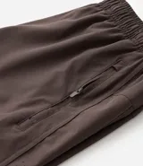 Bermuda deportiva gris con cintura elástica, cordón de ajuste, bolsillos con cremallera, recorte lateral con agujeritos y abertura en el bajo.