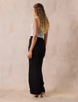 Pantalón negro de rayón con bordados florales, pretina ancha elastizada en punto smock y corte palazzo. Marca Liv Los Angeles.