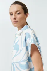 Túnica corta color blanco con estampado floral celeste y base color salmón.