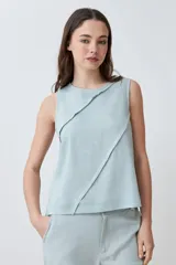 Blusa sin mangas color durazno, confeccionada en lino con efecto desflecado.