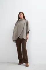 Ruana color crudo de lana fina sin teñir, con capucha, bolsillos y terminaciones envivadas. Tiene un broche para usar cerrada. Es una prenda oversize sin forro, cómoda, versátil y fácil de combinar.