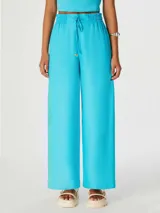 Pantalón celeste de corte palazzo con cintura elastizada y cordón ajustable.