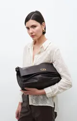 Bolso bandolera de cuero sintético color chocolate, con solapa y cierre metálico dorado.