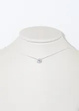 Collar plateado con dije circular con una zirconia engarzada.