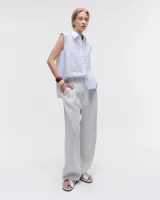 Camisa blanca sin mangas confeccionada en voile de algodón liviano. Tiene cuello camisero, cartera con botones de nácar, bolsillo plaqué en el delantero, costura en centro espalda y recorte en cintura trasera con tajo que se superpone. El ruedo es escalonado, más corto adelante.