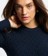 Sweater azul marino de punto con textura de ondas, cuello redondo y mangas largas.