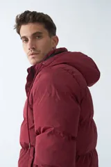 Campera puffer negra de nylon con capucha ajustable, cierre frontal con botones a presión y bolsillos laterales.