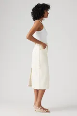 Falda midi color crudo con costuras a contratono y abertura en el lateral.