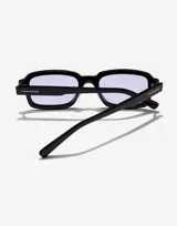 Gafas de sol unisex Hawkers Point, con montura rectangular negra y lentes color lavanda.