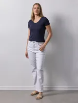 Pantalón de jean blanco, de corte recto, tiro alto, pretina con pasadores, botón y cierre. Con bolsillos delanteros y traseros.