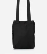 Bolso mini tipo bucket color negro, hecho en poliamida sin estampa. Tiene cierre delantero con tirador y cordón elástico, y tapa con enganche.